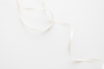 loops of white ribbon on gray text place.