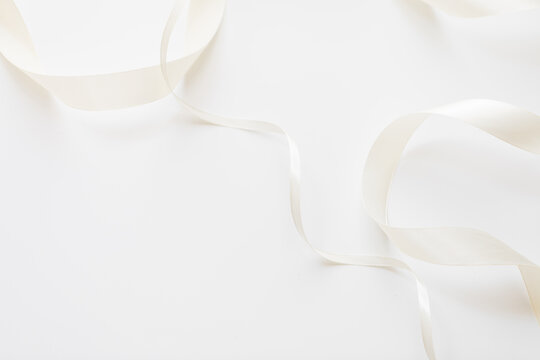 loops of white ribbon on gray text place.