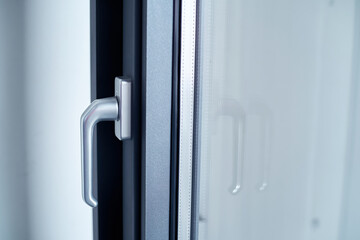 stylish chrome handle on a dark window frame.