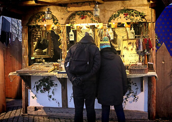 Christmas market: couple looking at a kiosk with trinkets on display