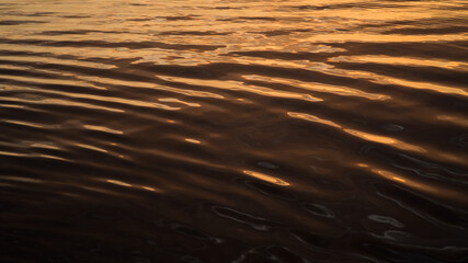 Warm light abstract water surface of a river during sunset
