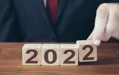 businessman changing a calendar to 2022