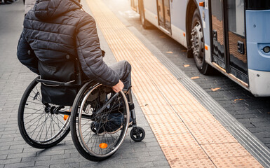 Person with a physical disability waiting for city transport with an accessible ramp.