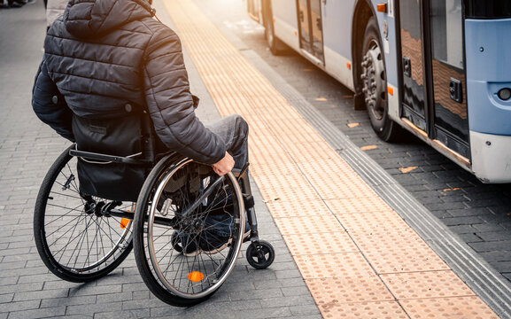Person with a physical disability waiting for city transport with an accessible ramp.