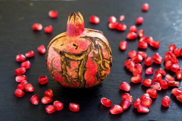 granatapfel mit schöner schale und kernen auf  dunklen untergrund