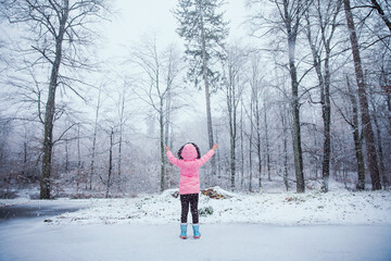 dziewczynka cieszy się z padającego śniegu zimą, zima przyszła - obrazy, fototapety, plakaty