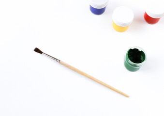 Painting brush and multicolored paints on white background
