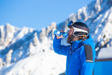 Skier drink water in mountains