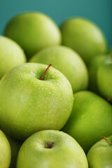 Ripe and juicy green apples on a green background.