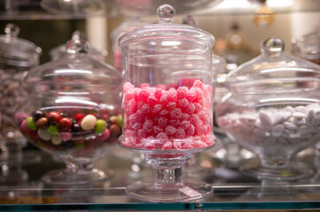 Fototapeta na wymiar Candy shop display with glass jars filled with jelly candies and bonbons