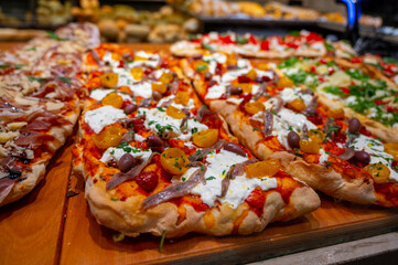 Fresh baked focaccia or pala romana pizza with vegetables and cheese in bakery in Parma, Emilia Romania, Italy close up