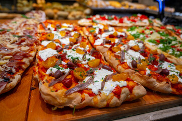 Fresh baked focaccia or pala romana pizza with vegetables and cheese in bakery in Parma, Emilia...