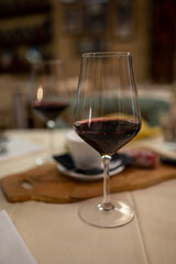 Dinner with glass of dry red wine in traditional Italian osteria restaurant