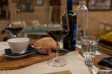 Dinner with glass of dry red wine in traditional Italian osteria restaurant