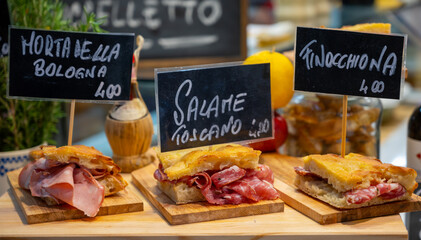 Italian street food, Parma ham sandwiches, bread with cured meats in market in Florence, Italy...