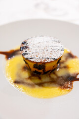 Tasty Italian dessert, small hot cake with chocolate and white gravy on white plate
