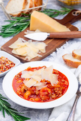Minestrone soup with cavatappi pasta, beans and vegetables, served with crispy bread, vertical