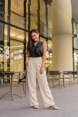 Full length portrait of beautiful Asian woman outdoors at coffee shop restaurant