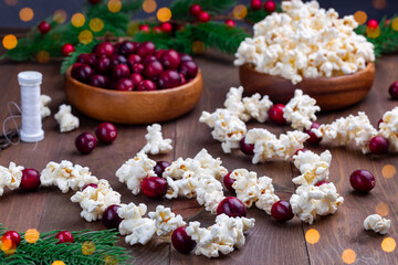 Traditional handcrafted Christmas popcorn garland with red cranberries, bokeh effect, horizontal