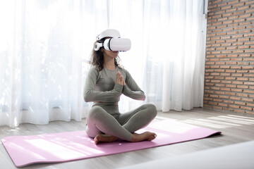 Fitness and lifestyle of the future, VR Yoga, Beautiful woman wearing virtual reality glasses while practicing yoga at home.