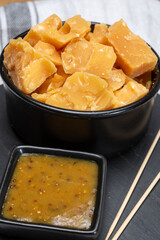 Cheese tasting, small pieces of old Dutch hard cheese and bowl with homemade dill-mustard sauce