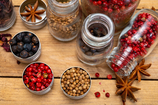 Professional set of gin spices in small bottles, pink pepper, hibiscus flowers, juniper berries, cardamom, coriander seeds, star anise - Powered by Adobe
