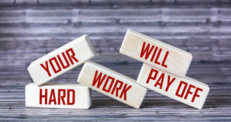 Your hard work will pay off inspirational text on wood block and wood table