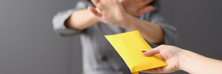 Business woman refuses money in yellow envelope closeup