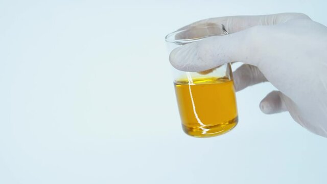 Essential oil. Transfer liquid. Natural cosmetic. Aromatherapy. Natural Ingredients. Beauty lab. Flask of oil and a hand in a white glove. Engine oil additives. Production.