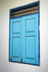 Obraz na płótnie Canvas Pastel colorful blue wooden window frame on cement white wall wite space area. Building exterior design and object photo.