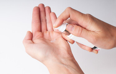 The girl applies cosmetics from a bottle to her hand.