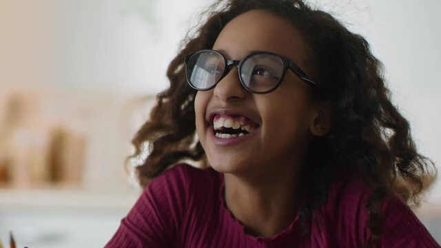 Fun and happiness. Close up portrait of adorable happy funny girl nerd wearing eyeglasses laughing loud at home
