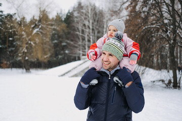 Fototapeta na wymiar Fathers of Daughters, Raising Girls. Dads Having a Baby Girl. Happy father playing with little baby toddler girl daughter in winter park, forest. Happy family on winter weekend, Christmas holidays