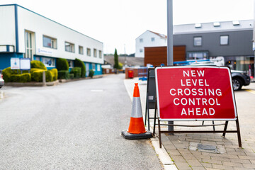 'New level crossing control ahead' sign in a town centre informing the public of the change