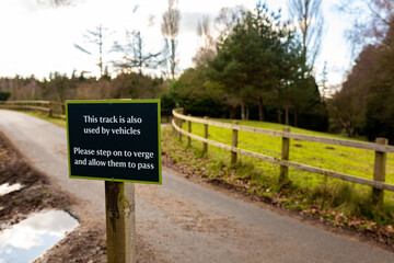 'Track is used by vehicles' sign politely asking the public to use the verge and allow vehicles to pass