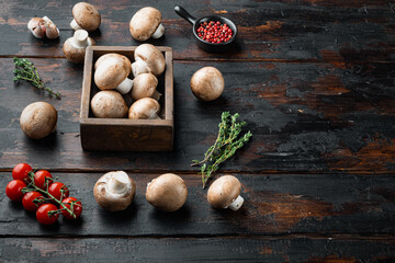Raw mushrooms champignons, on old dark  wooden table background , with space for text  copyspace