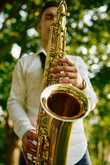 Young saxophonist plays melody on golden saxophone
