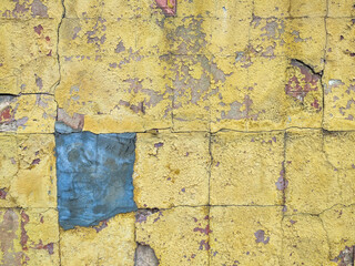 old concrete wall with cracks with stains of yellow paint texture background