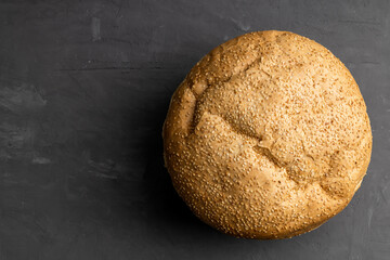 round bread loaf with sesame on a concrete background. copy space