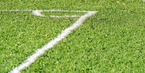 Green artificial football background close-up.