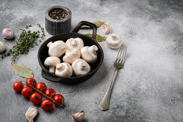 Heap of whole raw fresh champignons, on gray stone table background, top view flat lay, with copy...