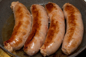 Fried meat sausages in a pan, food for men.