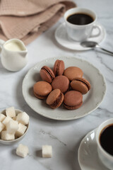 A cup of cappuccino with chocolate macaroons . Photo on a light gray marble background.