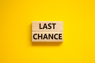 Time to last chance symbol. Concept words Last chance on wooden blocks on a beautiful yellow...