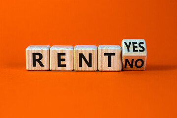 Time to rent symbol. Turned a wooden cube and changed the words rent no to rent yes. Beautiful orange table, orange background. Business and time to rent concept. Copy space.