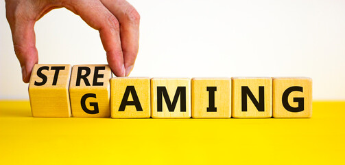Gaming and streaming symbol. Businessman turns wooden cubes and changes the word gaming to...