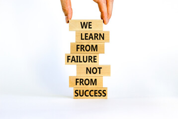 Failure or success symbol. Wooden blocks with words We learn from failure not from success. Beautiful white background, copy space. Businessman hand. Business, learn from failure or success concept.