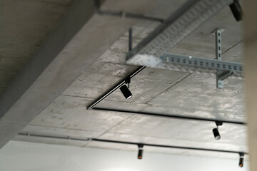 Black track lights on a concrete ceiling.
