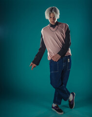 Young adult man in casual outfit wear looking at camera, holding skateboard near face and standing...
