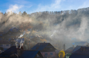 Smoke over the houses in the village on an autumn morning